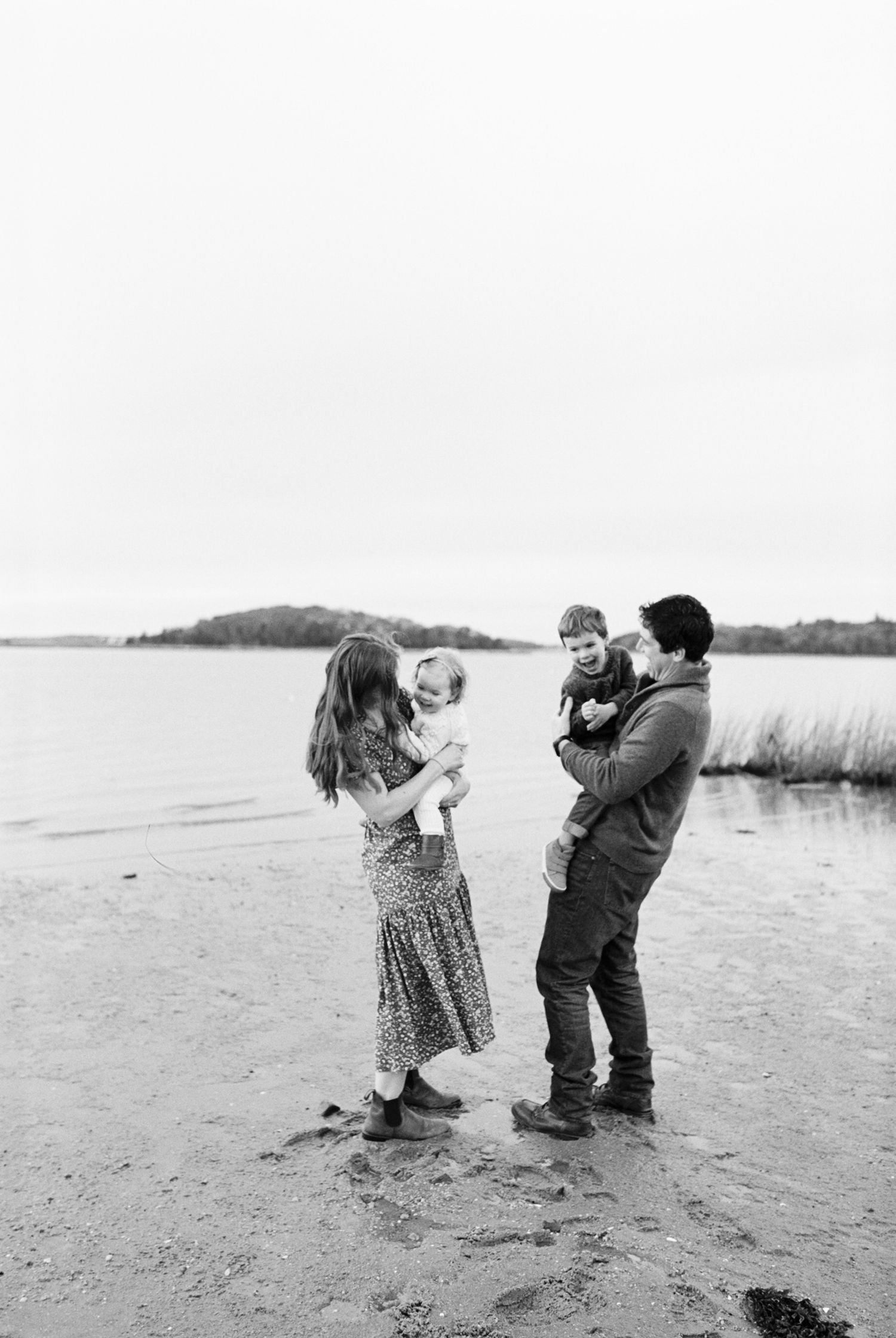 A playful sequence of photos showing two children interacting on a beach in black and white.