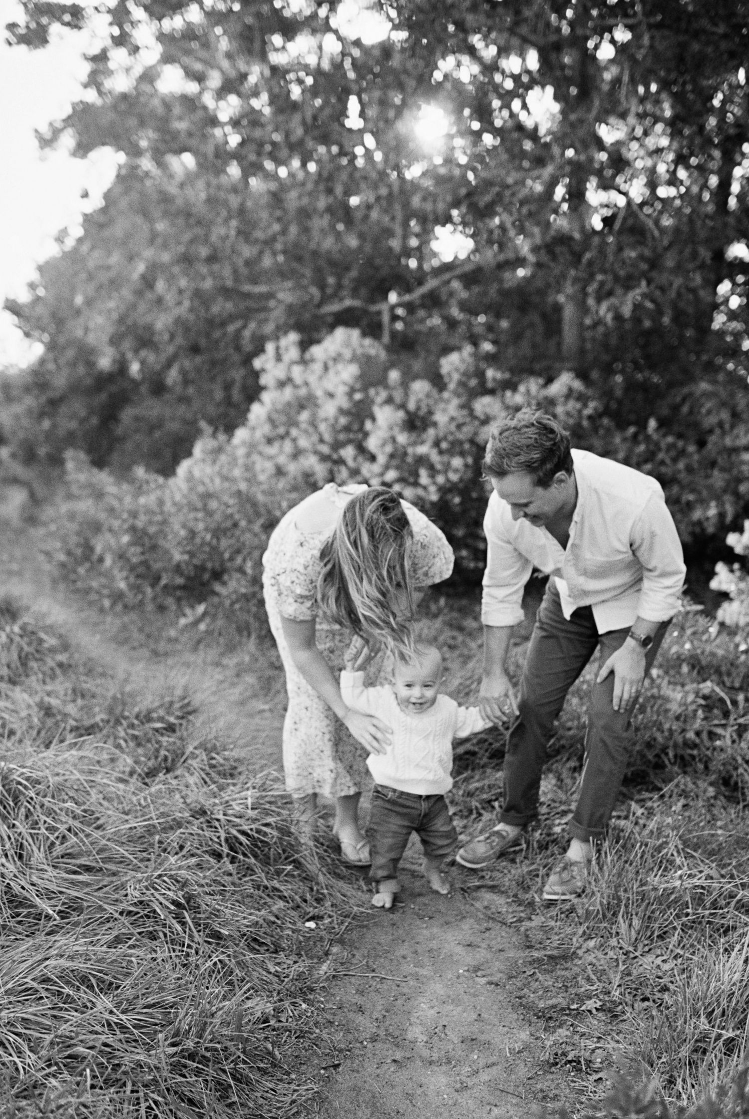 Black and white photos of a family exploring together on a nature trail.