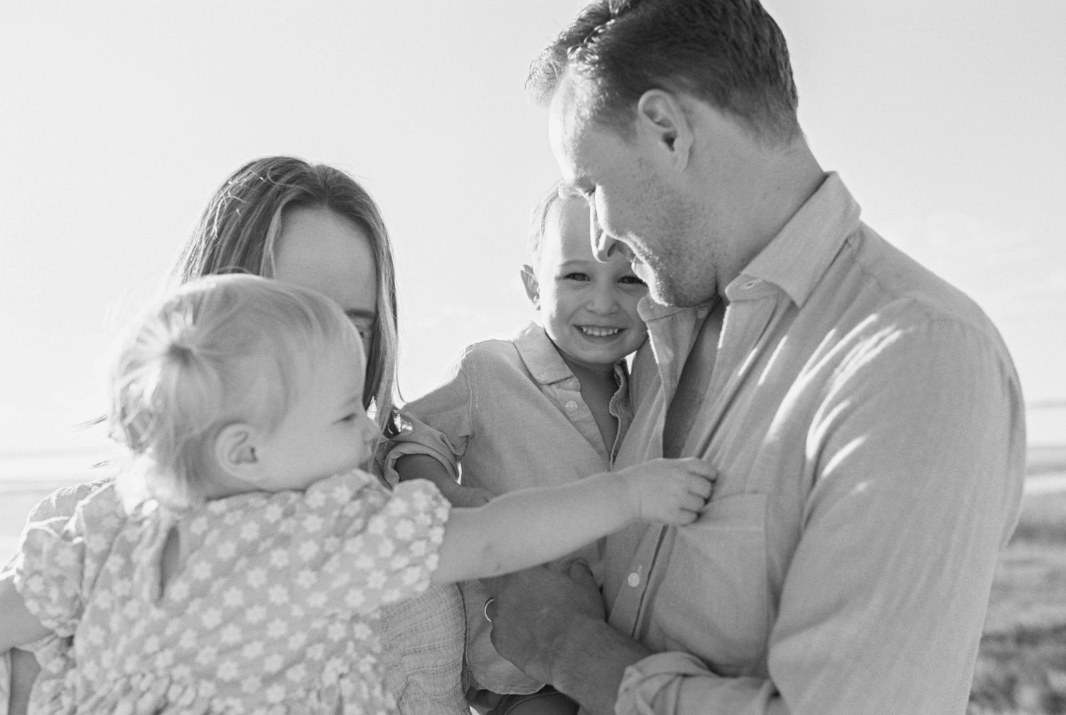 Black and white series of intimate family portraits showing tender moments and laughter together.