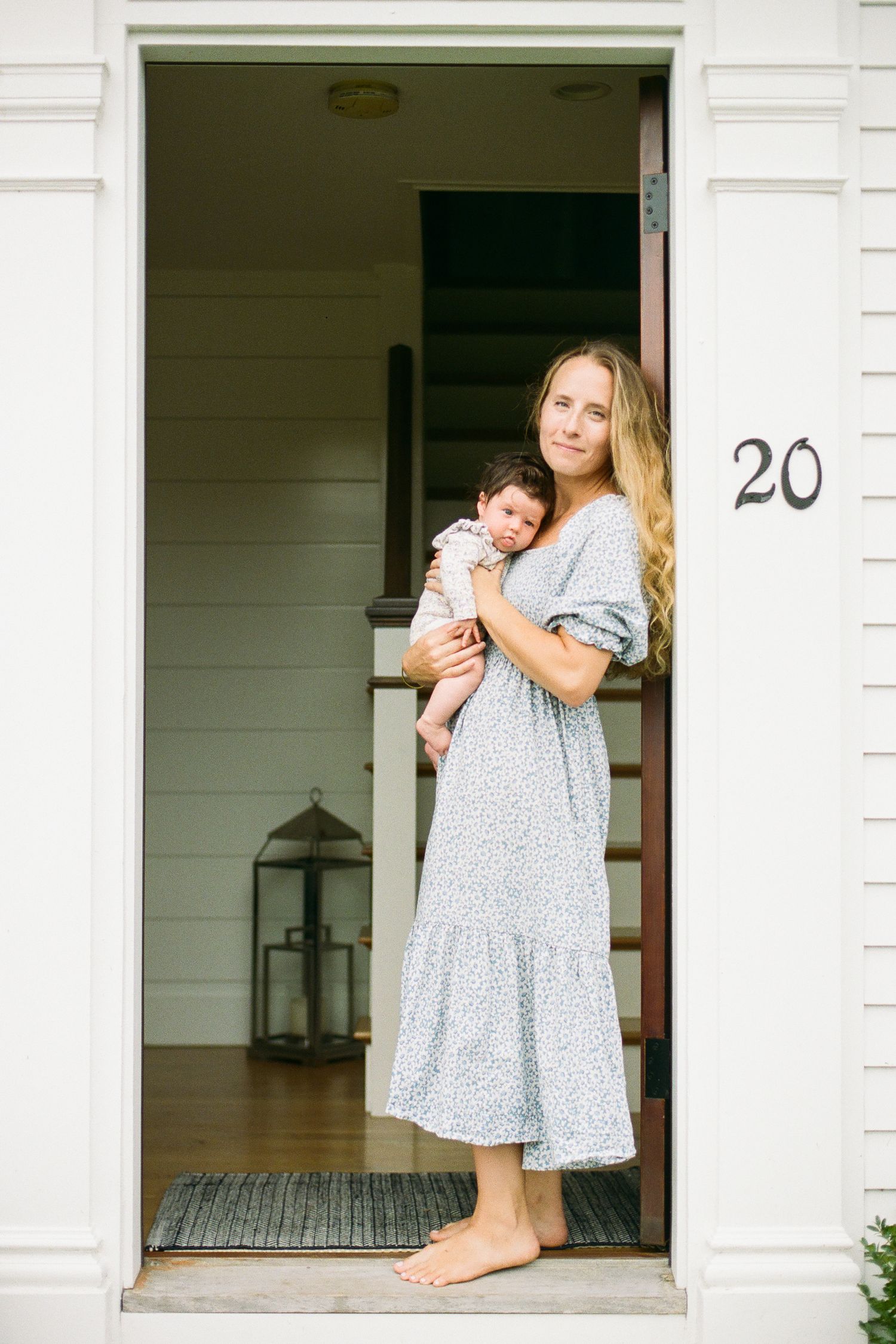Family moment captured in doorway of white house with number 20.