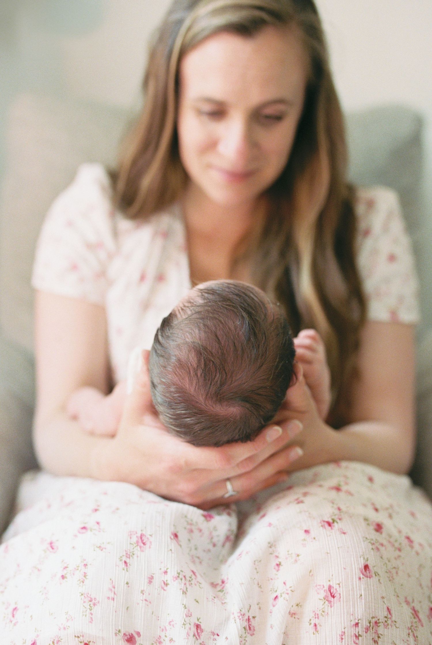 Newborn baby sleeping peacefully on a floral patterned blanket.