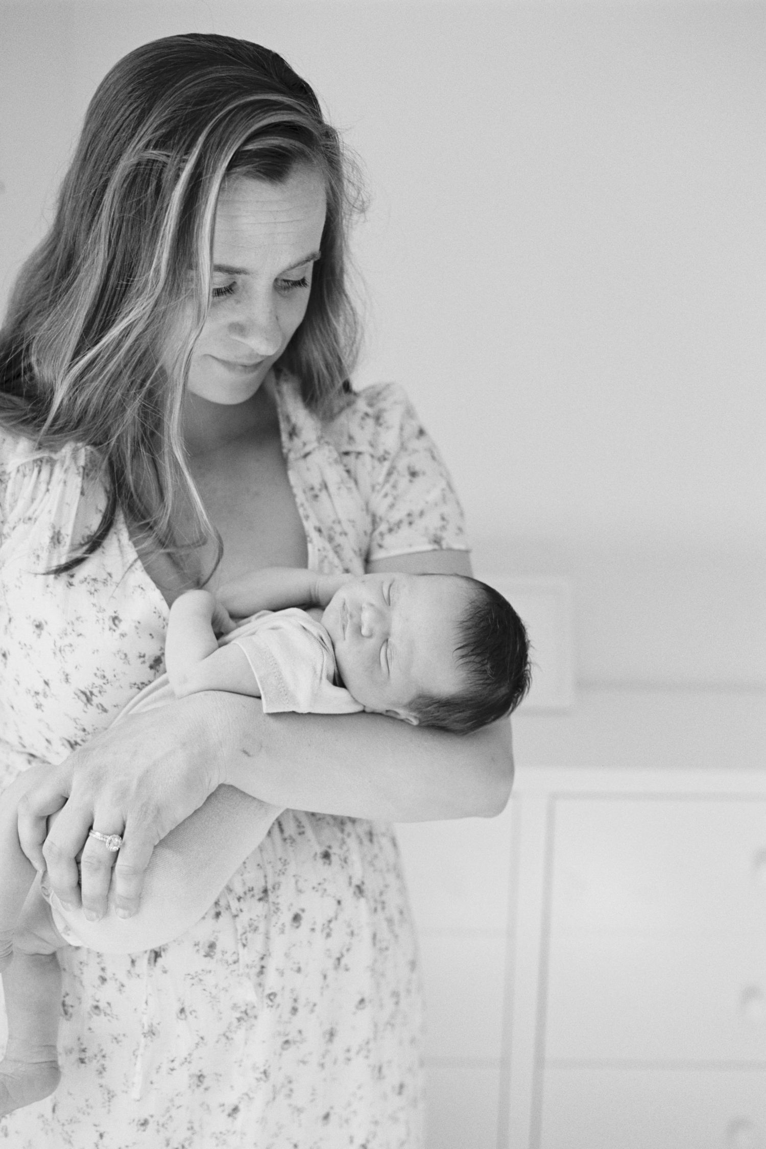 A serene black and white portrait of mother cradling sleeping newborn.