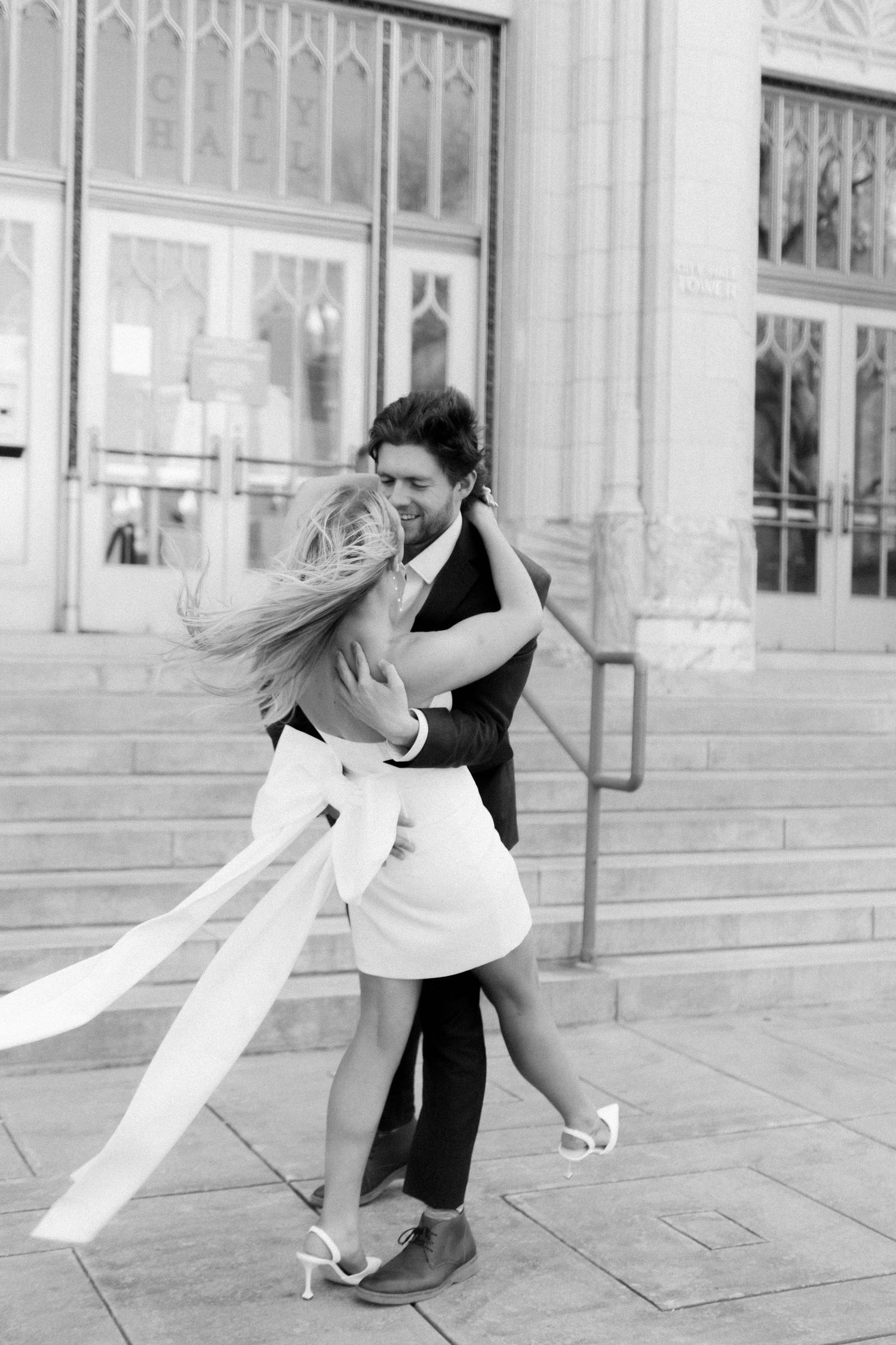 A black and white photo capturing a romantic dance dip on stone steps. Georgia state capitol wedding photographer.