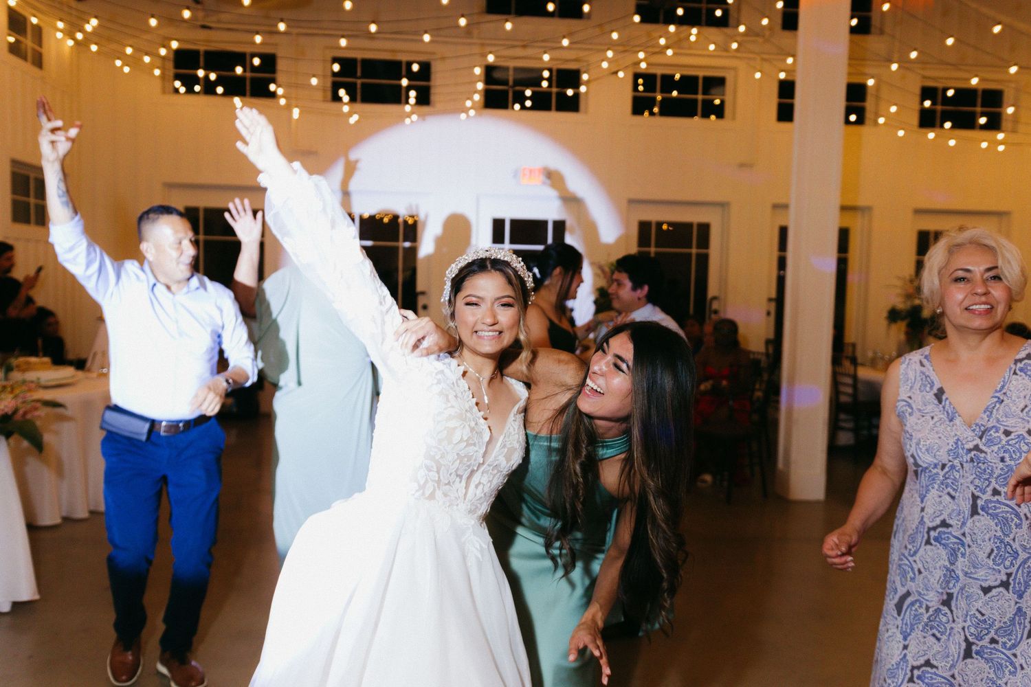Wedding reception dance party with guests celebrating under hanging string lights. Cumming, Georgia wedding photographer.