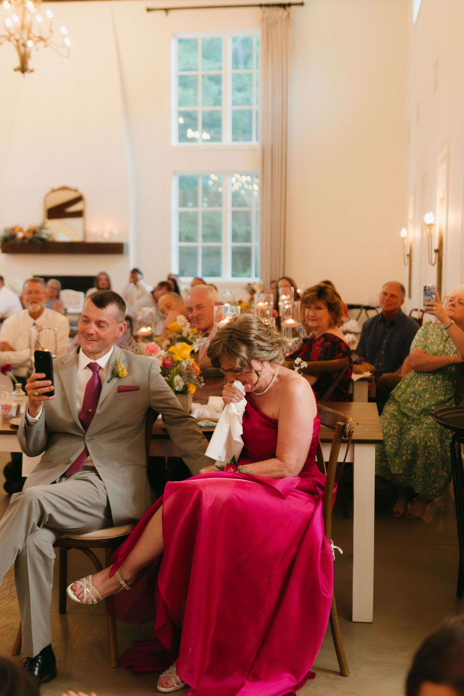 Wedding reception with guests seated at tables in bright venue with pink accents. Commerce, Georgia wedding photographer.