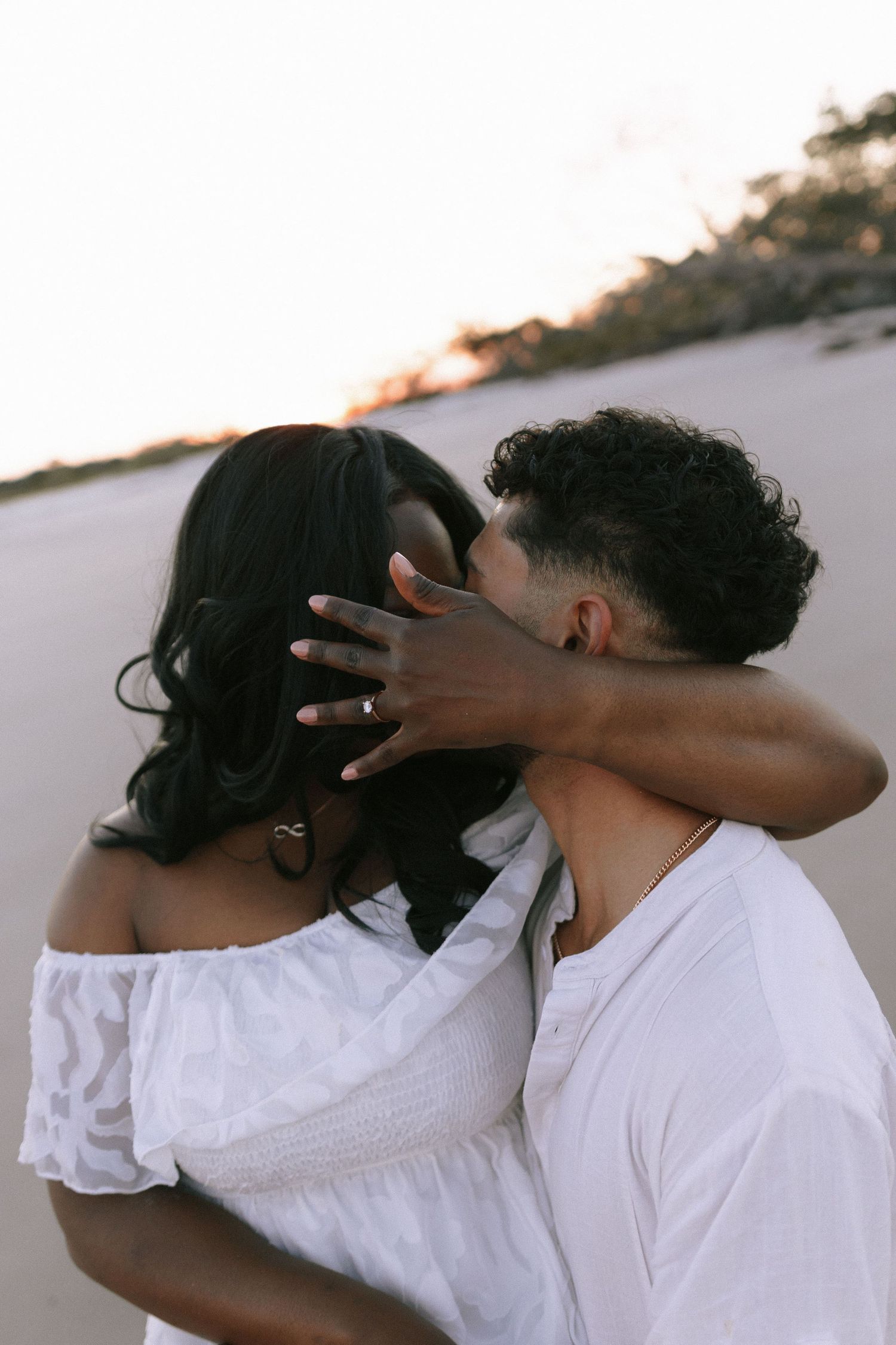 Intimate moment captured between couple in white outfits during beach sunset. Jekyll island elopement photographer.