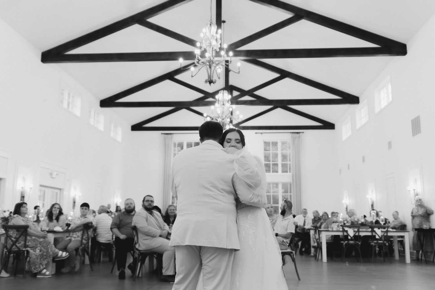 Wedding reception in white chapel with exposed wooden beam ceiling. Commerce, Georgia wedding photographer.