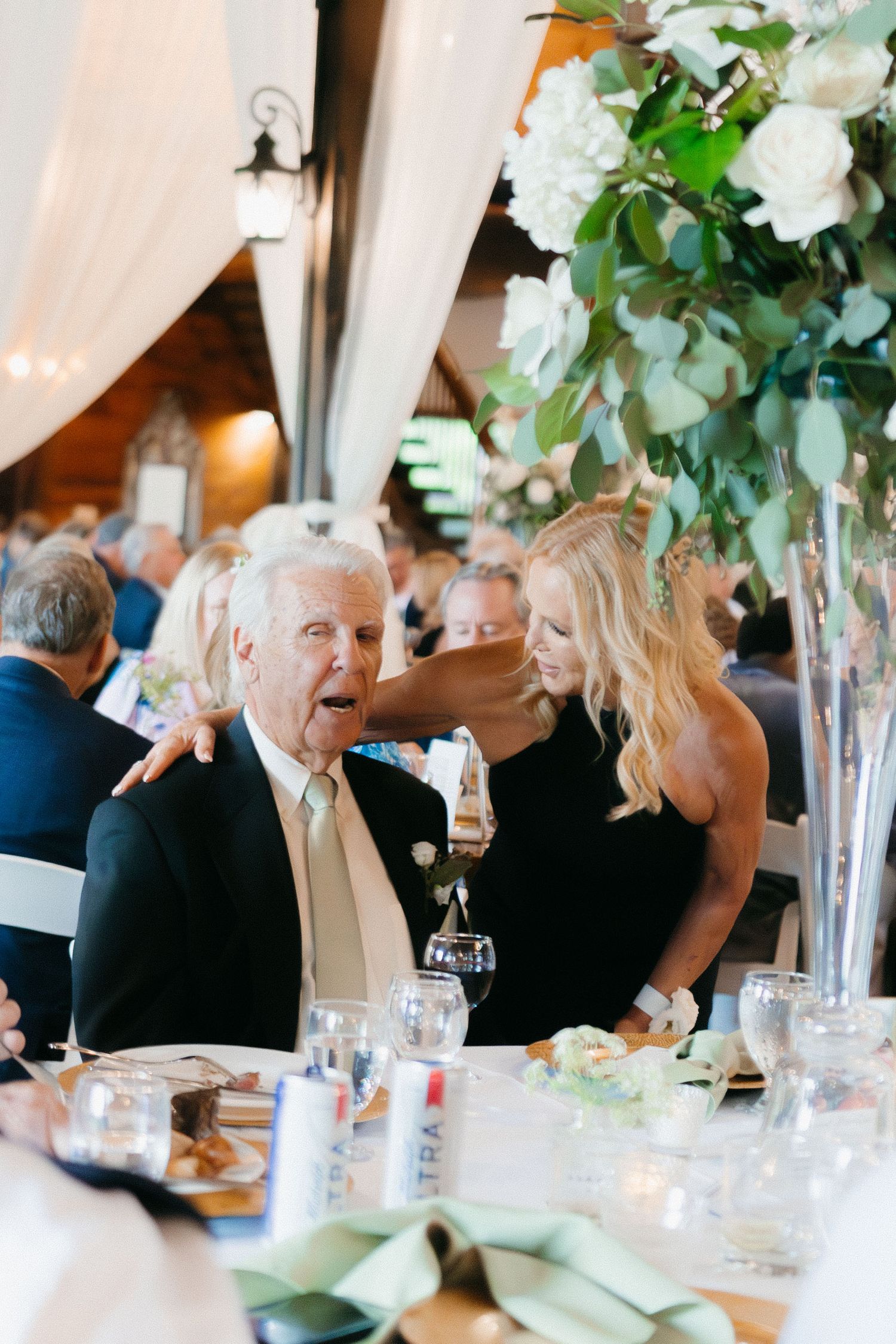 Elegant wedding reception table set with tall floral centerpieces and white linens. Dahlonega, Georgia wedding photographer.