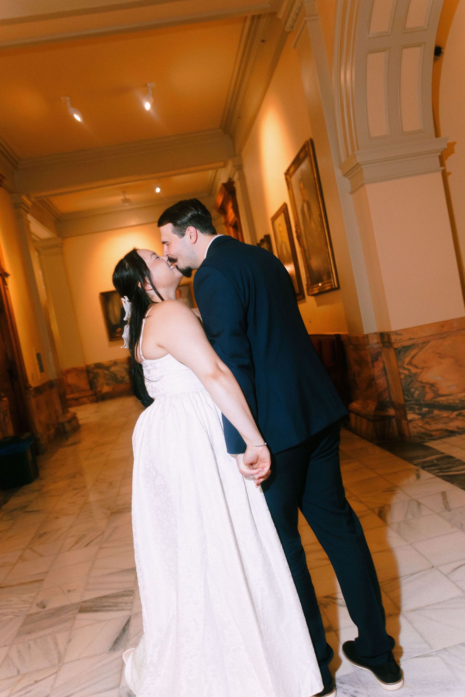 A romantic wedding moment captured in a warmly lit marble hallway. Georgia state capitol wedding photographer.