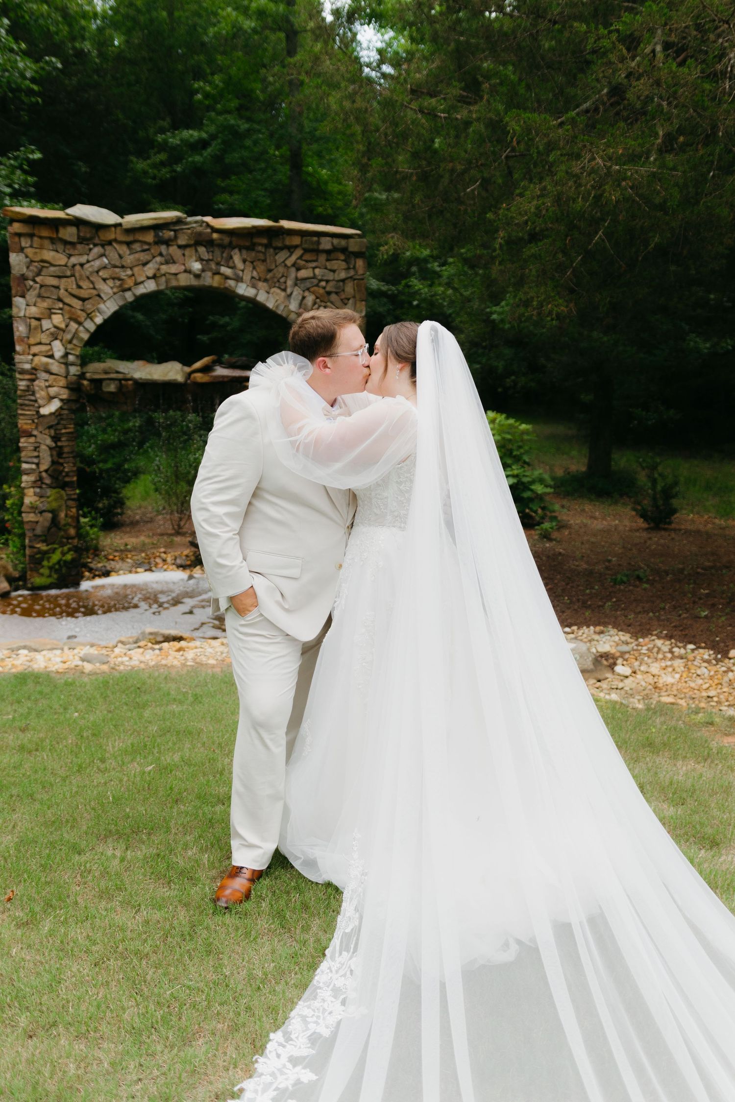 Romantic wedding portraits on a grassy lawn with flowing white veil catching the breeze. Commerce, Georgia wedding photographer.