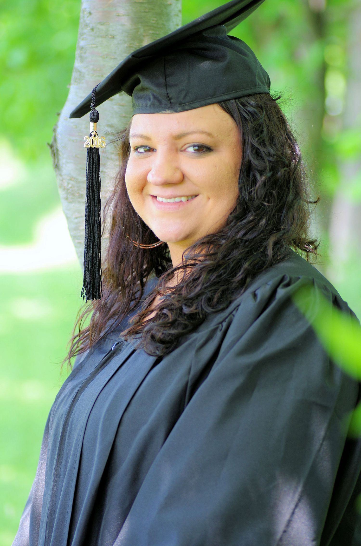 Graduation portraits taken under tree branches with natural lighting.