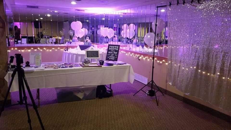 Purple-lit event space with white tablecloths and hanging decorations.