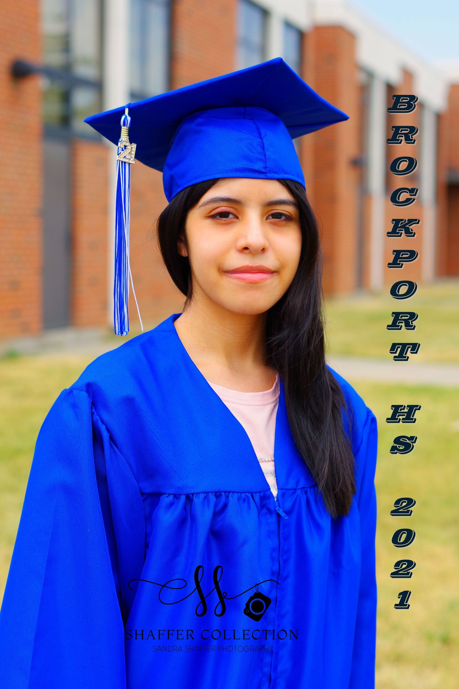 Graduate in traditional blue graduation attire shown against school building with class year text.