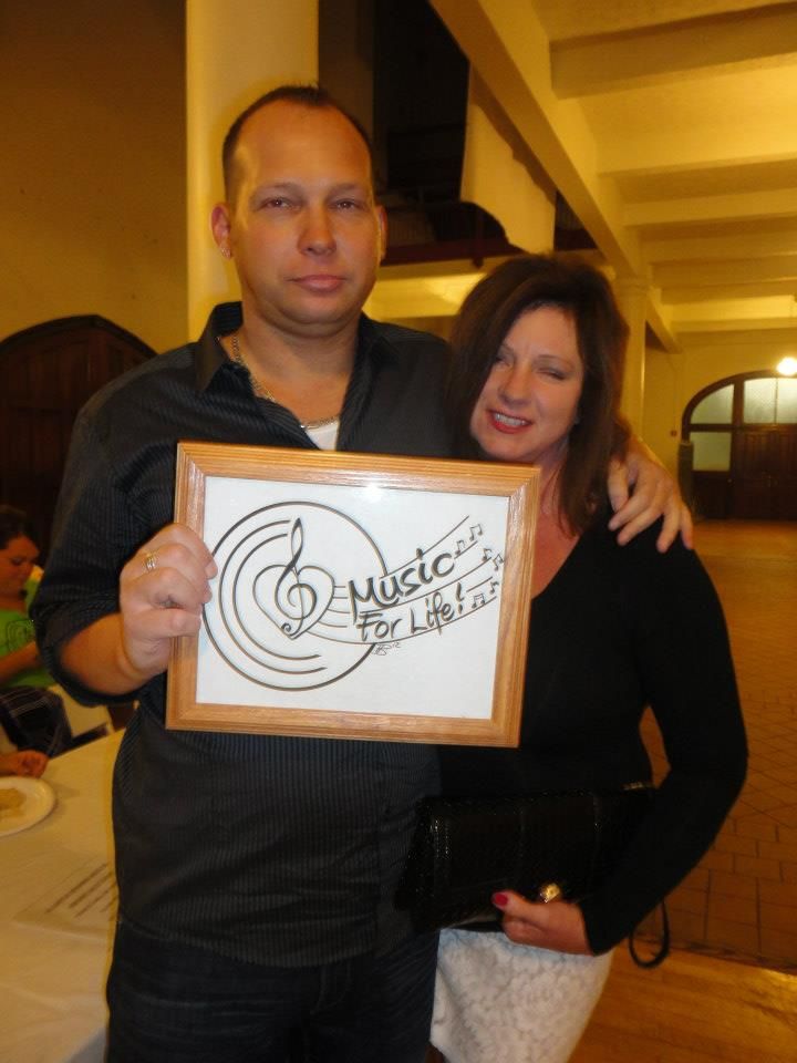 Group showing off matching framed artwork featuring musical notes at a social gathering.