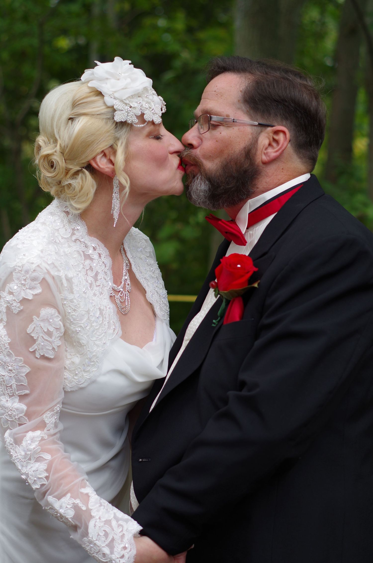 Intimate wedding portrait captured in a wooded outdoor setting.