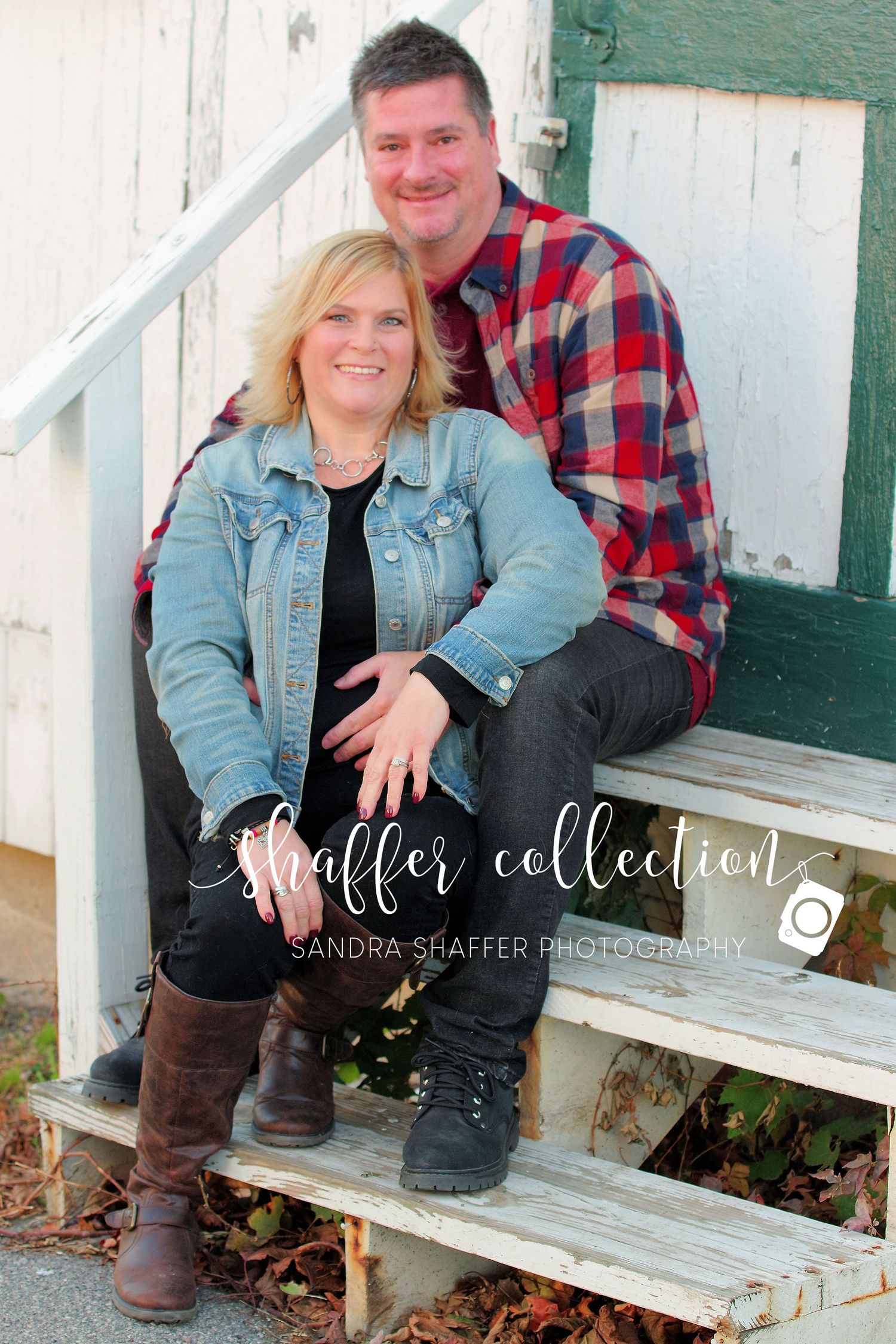 A couple sits together on rustic white wooden steps.