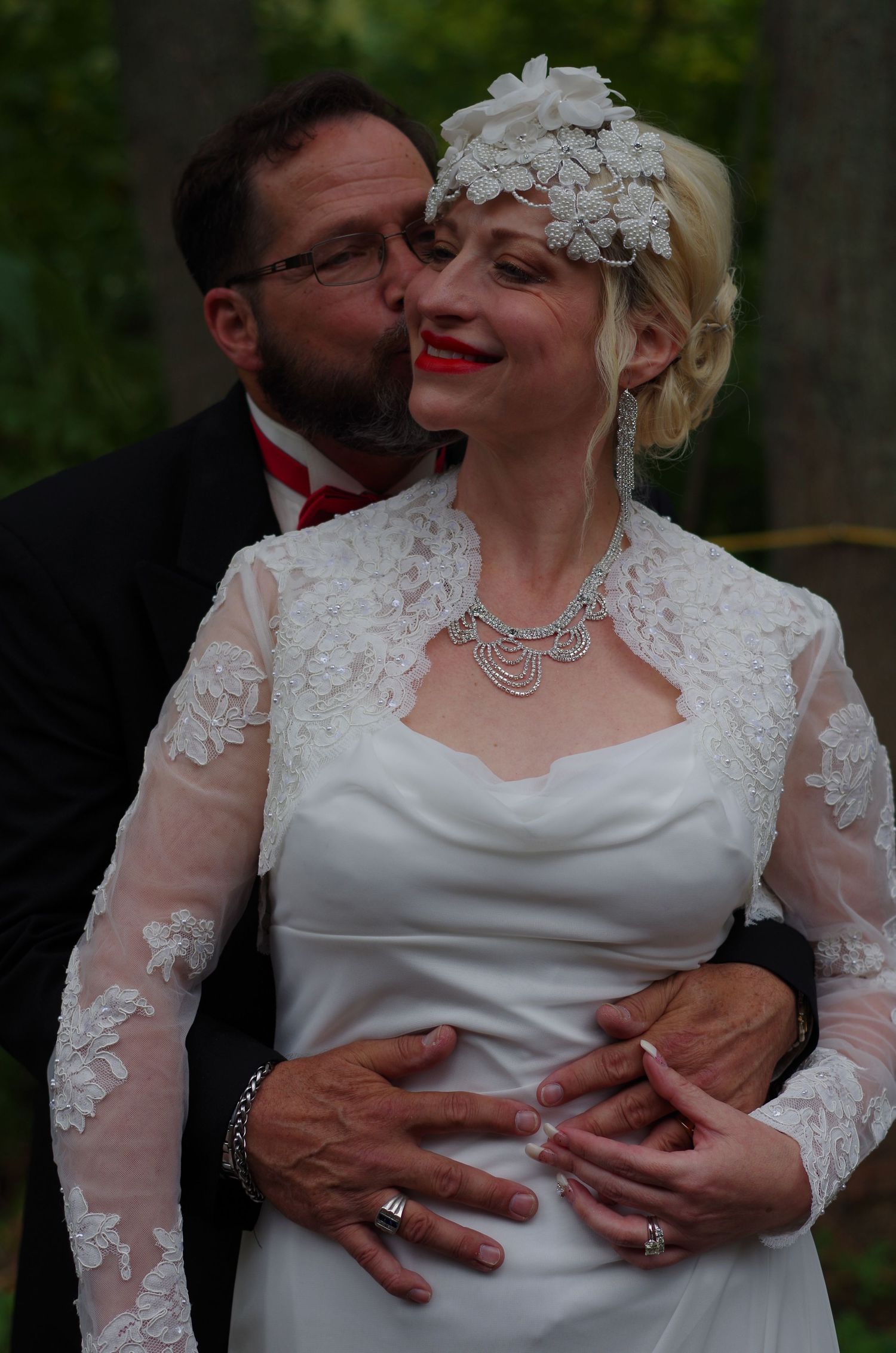 Tender wedding moment captured against natural forest backdrop.