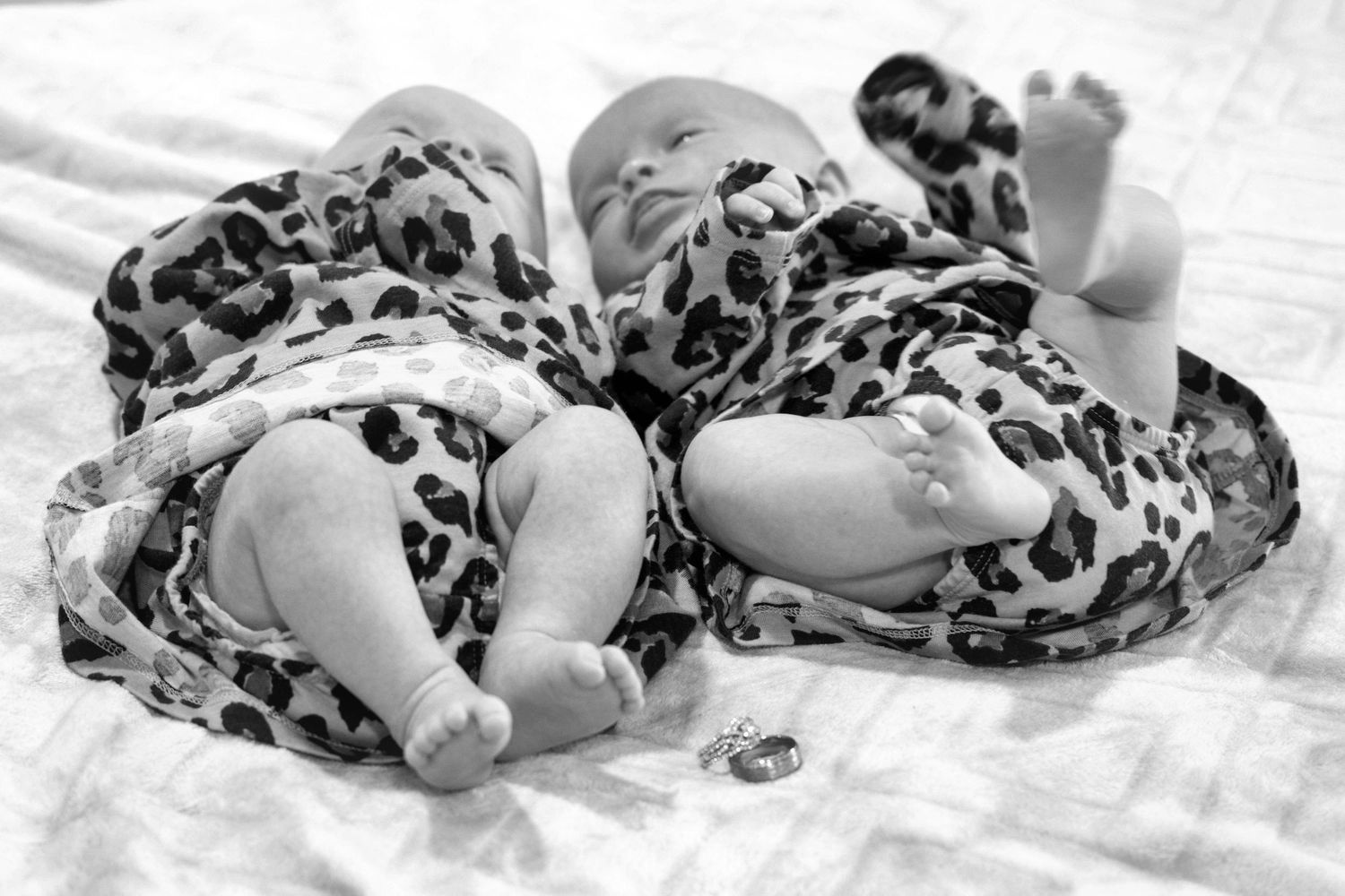 Baby lying on blanket wearing animal print outfit in black and white series.