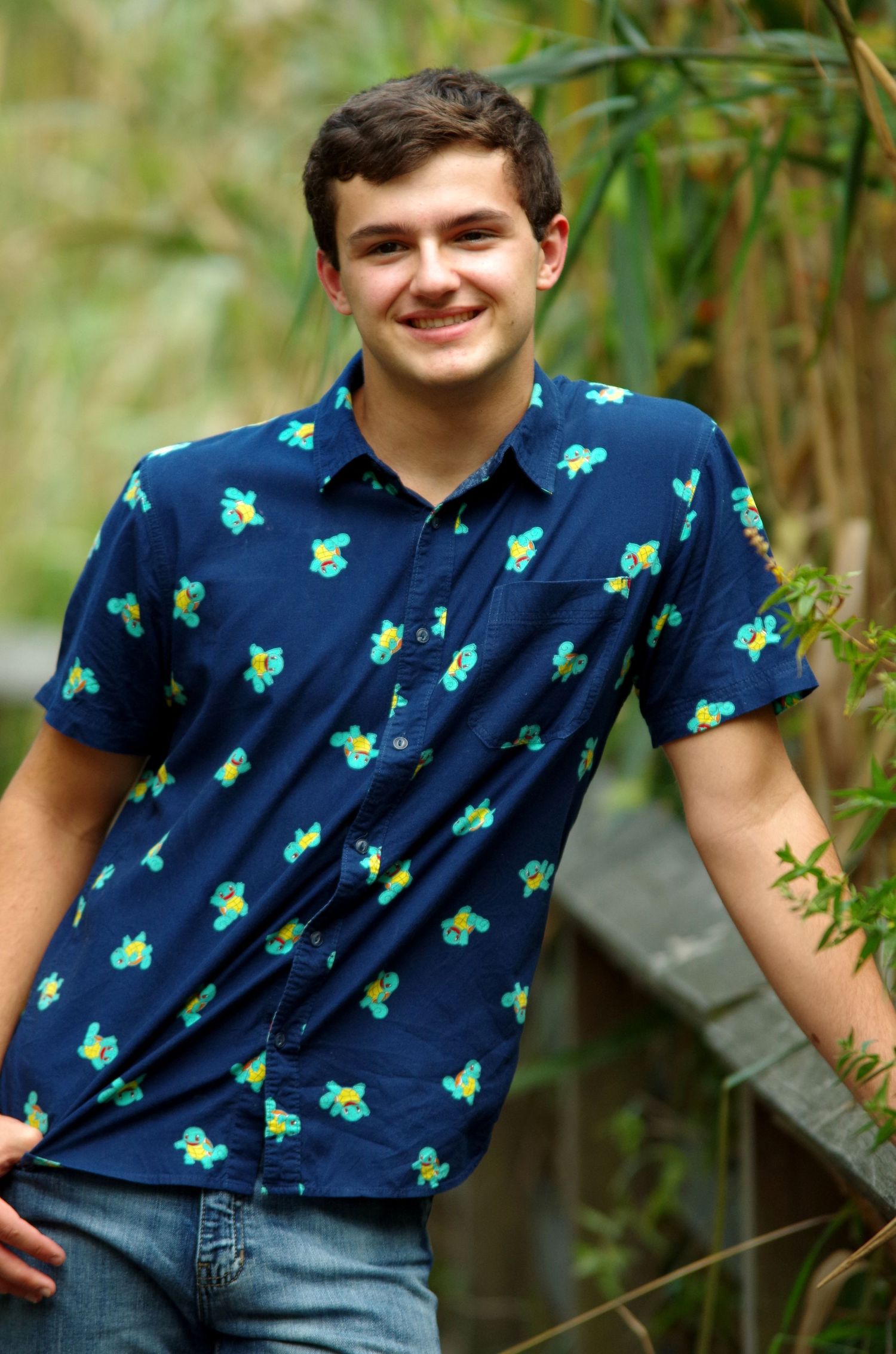 Navy blue shirt with tropical pattern photographed against lush green foliage.