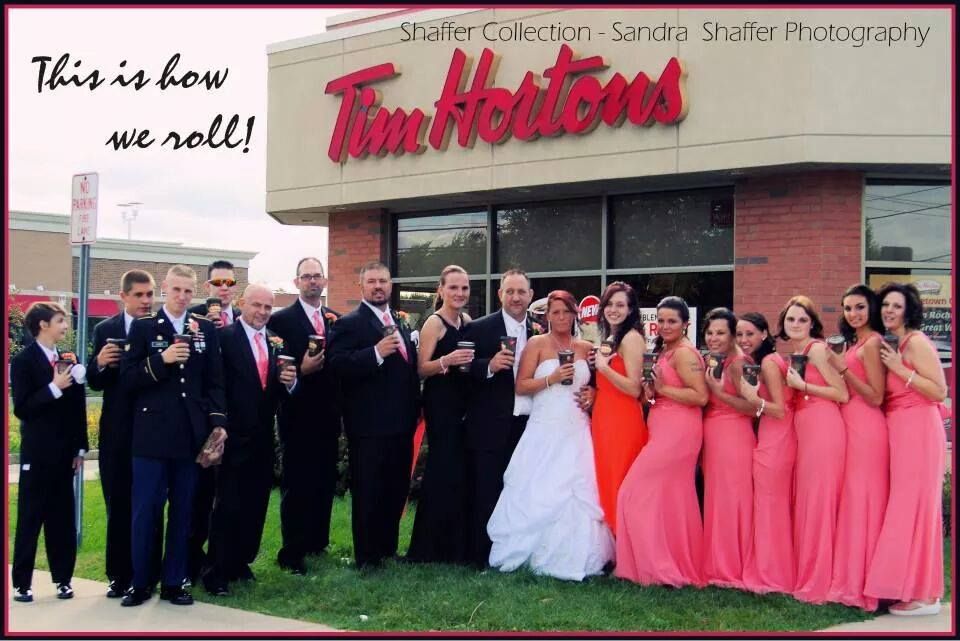 Wedding party poses outside Tim Hortons restaurant in formal attire.