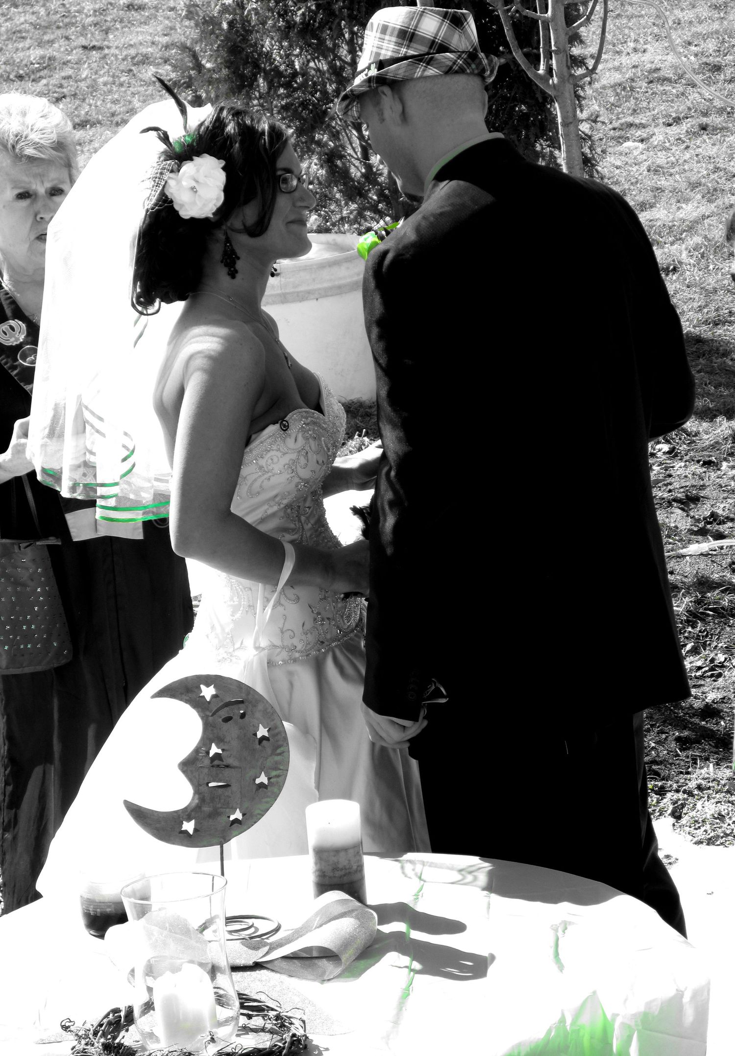 Black and white wedding photograph of outdoor signing ceremony.