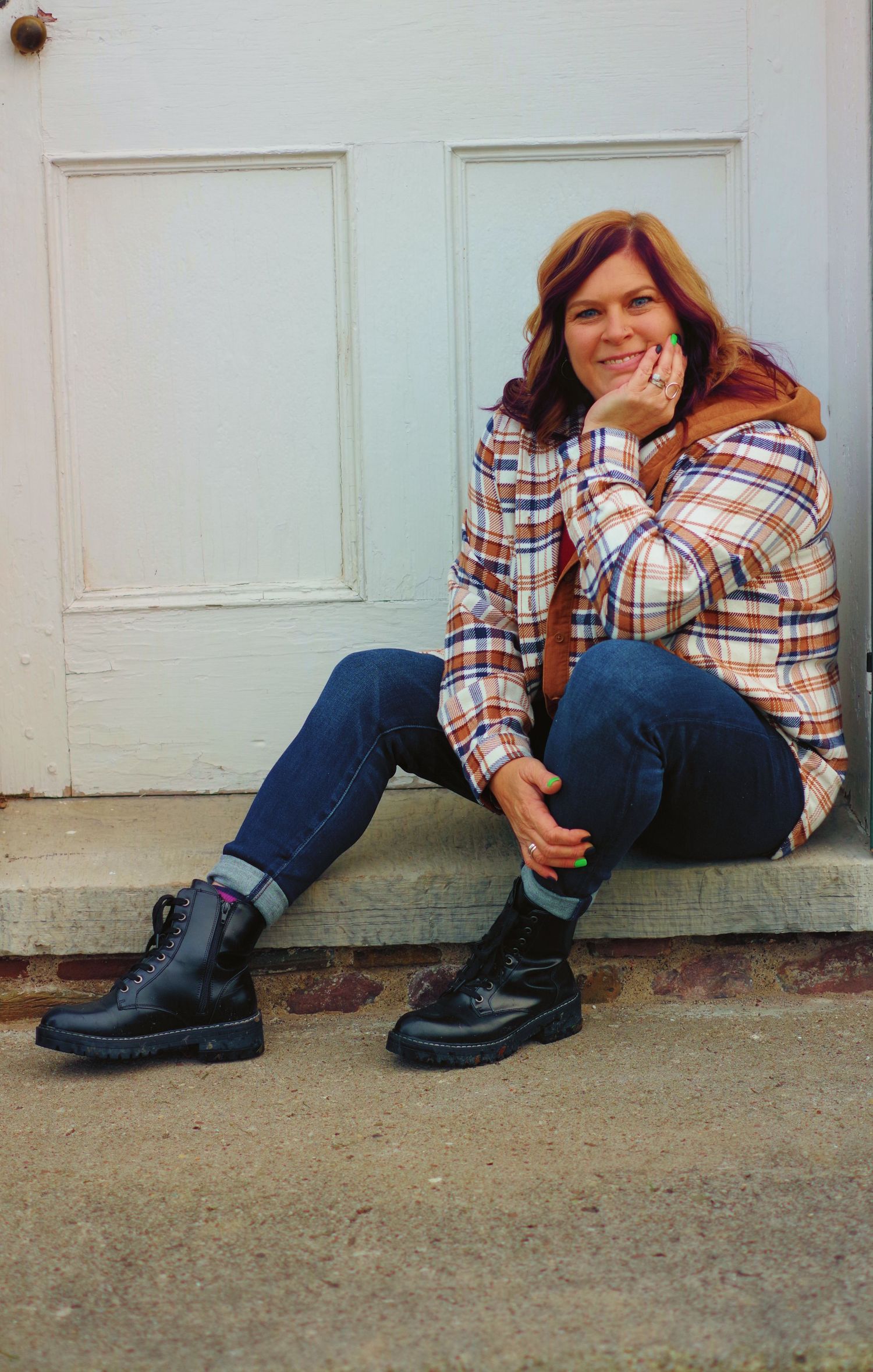 Casual portrait on concrete steps wearing plaid flannel and combat boots.