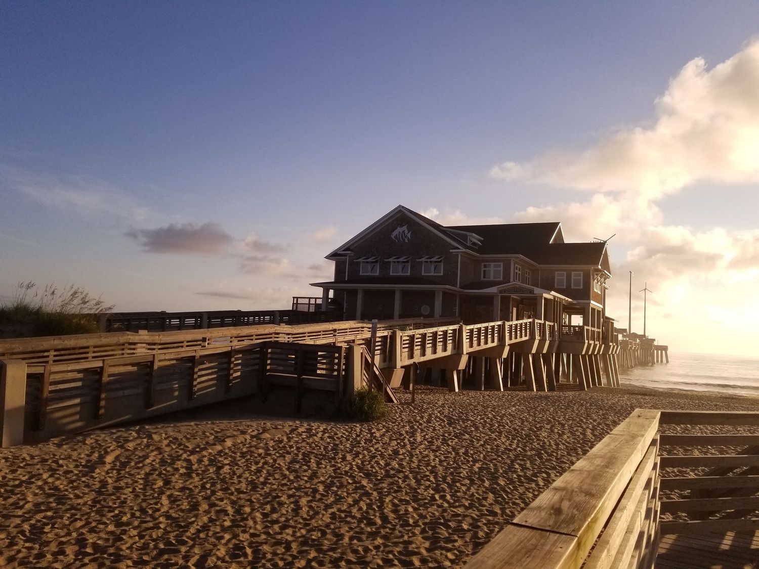 Panoramic view of beach houses along the coastline at sunset.