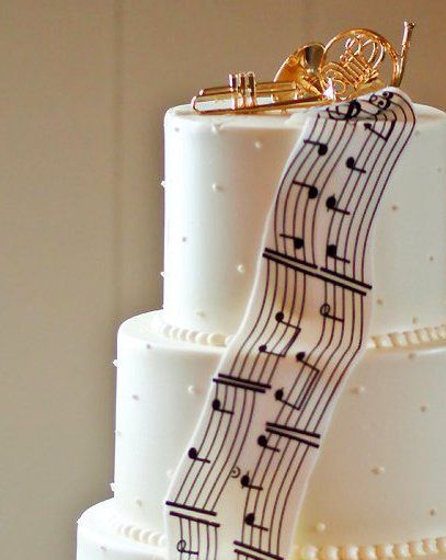 White wedding cake decorated with black musical notes and staff lines.