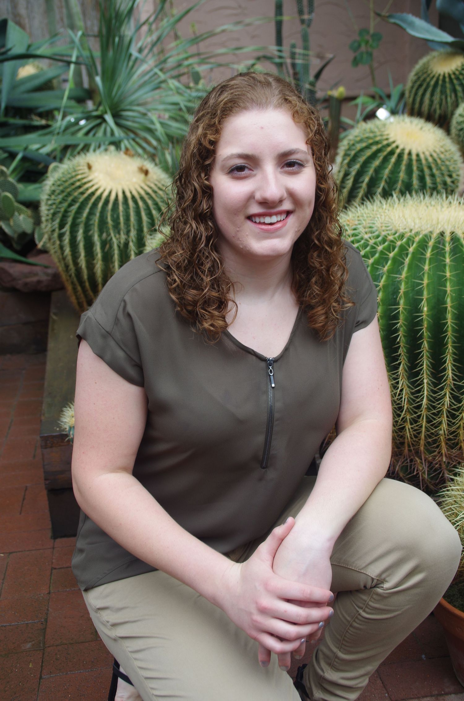 Green cacti and plants create a backdrop for a series of casual portrait poses in an outdoor setting.