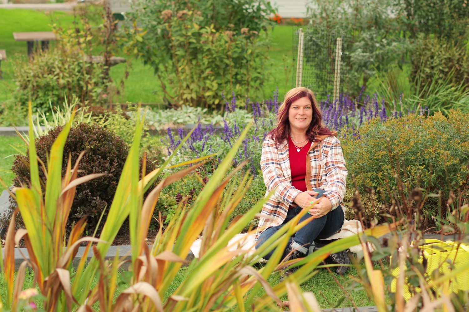 Outdoor garden portrait surrounded by vibrant plants and flowers in natural setting.