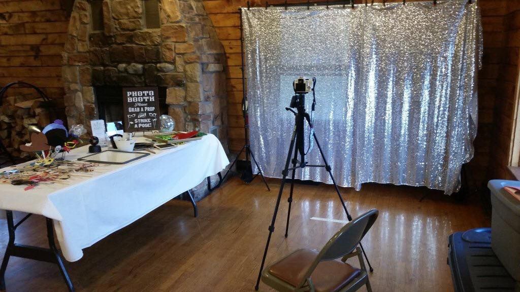 Indoor event space with white curtain backdrop and chairs set up for a gathering.