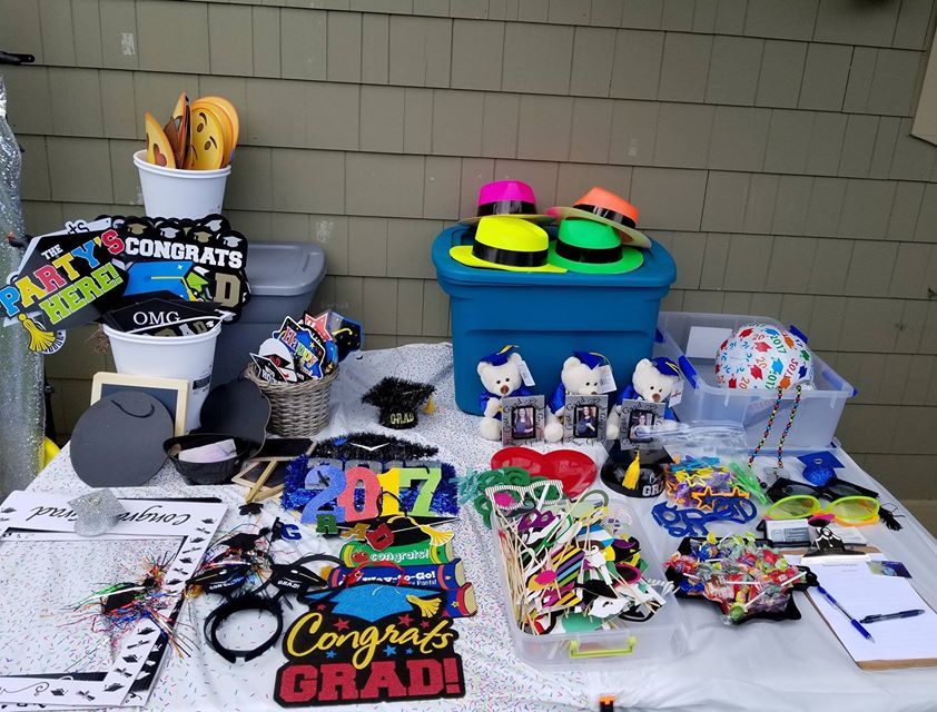 Long table display of colorful party favors and merchandise items at an event.