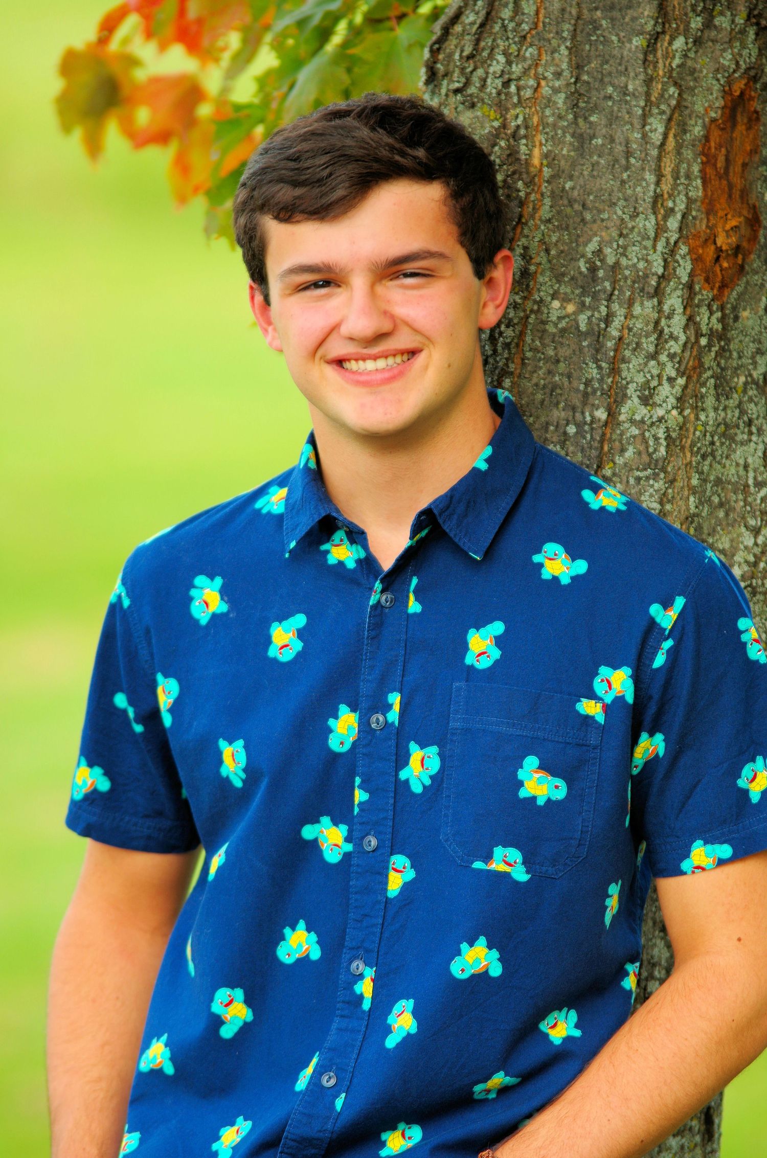 Close-up shots showing blue shirt with tropical pattern against vibrant green background.