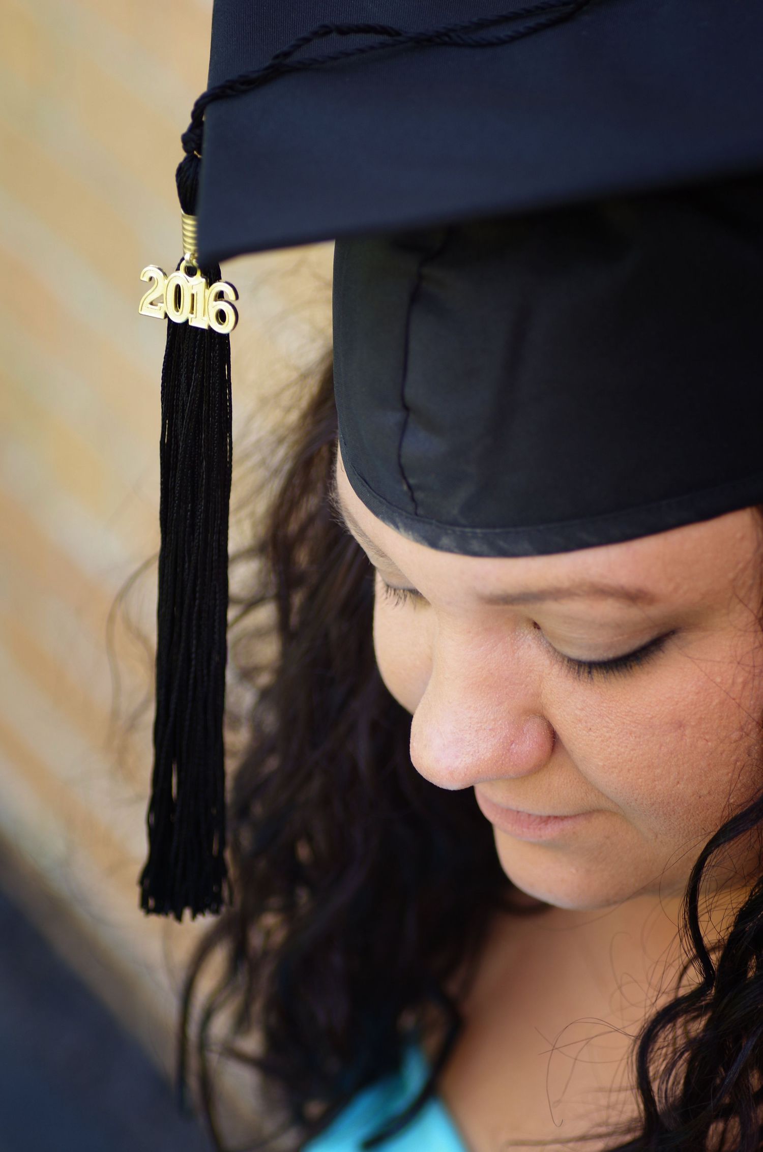 Close-up graduation portrait showing cap with 2018 tassel against blue sky background.