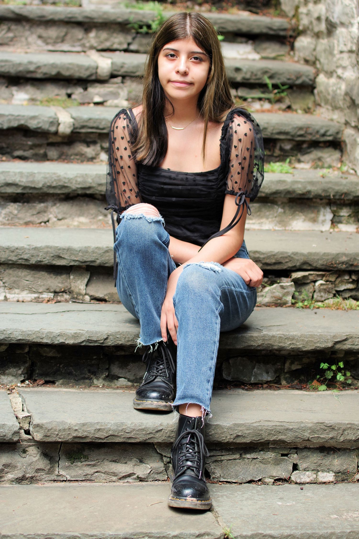 Casual portraits on stone steps wearing combat boots and ripped jeans.