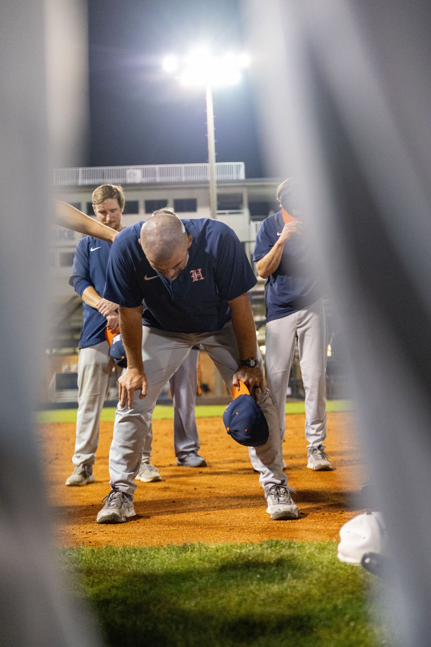 Habersham Central's baseball coach puts his head down in celebration after defeating Newnan High in the state playoffs.