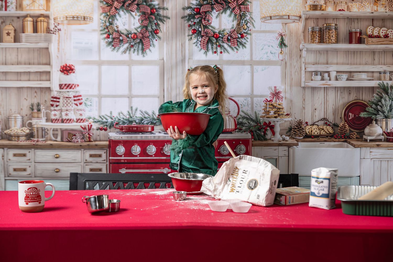 Young girl stirs pot with a kitchen backdrop for a Christmas mini session.