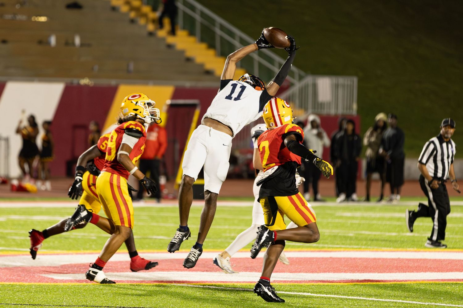 A Habersham Central wide receiver catches a pass between three Clarke Central defenders during a game played in Athens, Georgia.