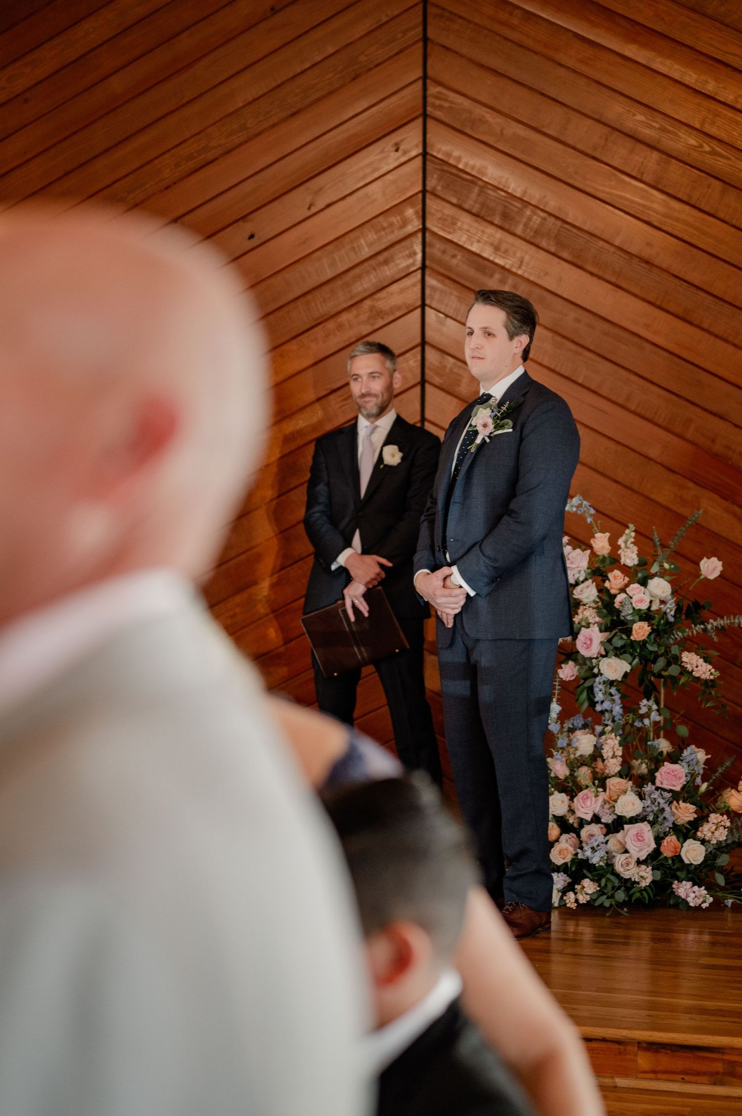 Groom seeing bride down the aisle for the first time at their spring wedding ceremony at historic Bishop Arts venue in Dallas, Texas