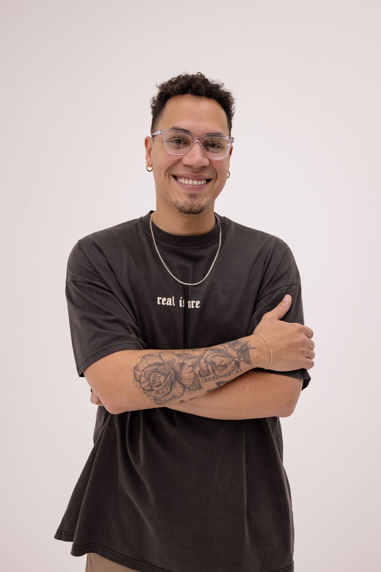 A midshot headshot portrait of a male musician in front of a white studio wall