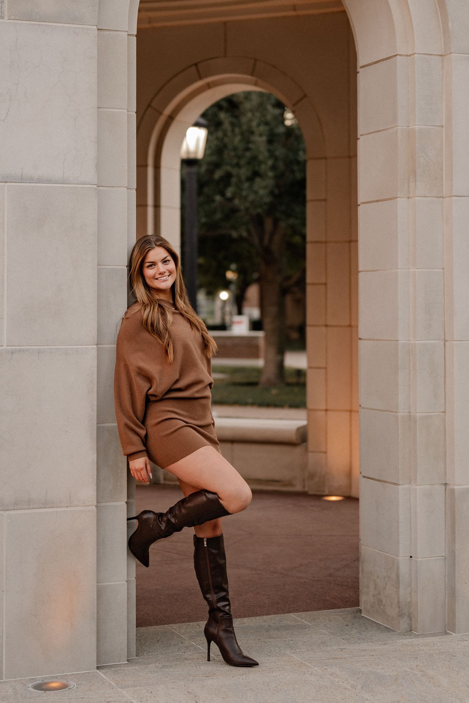 Senior girl posing in an archway at Southern Methodist University for a fall senior photo session in Dallas, Texas