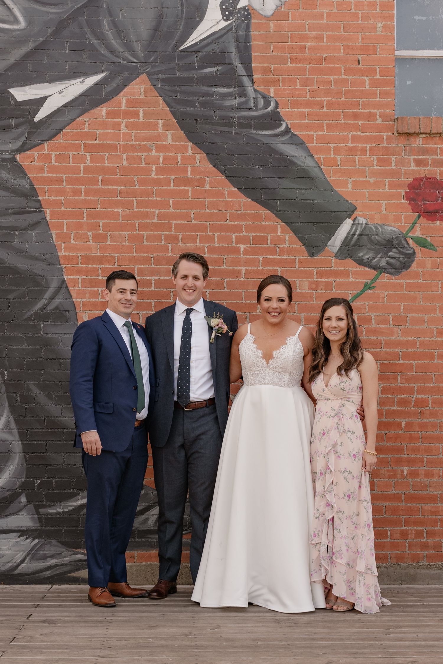 Wedding couple and friends pose together in front of a large mural outside of Bishop Arts area in Dallas, Texas