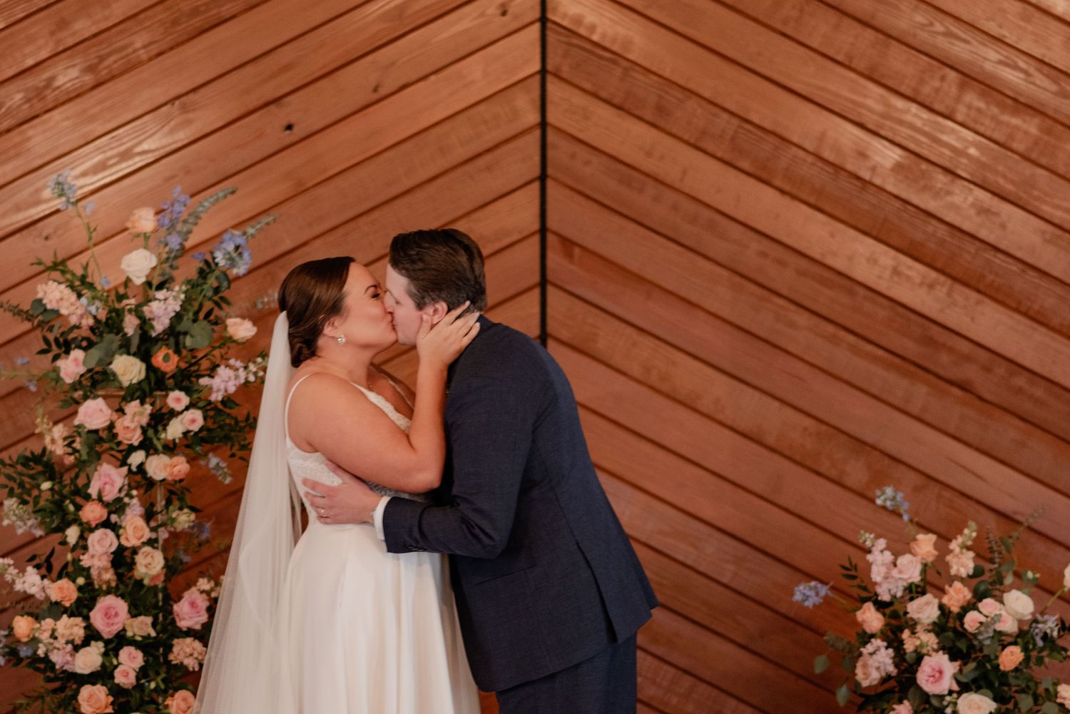 A romantic first kiss between bride and groom at the end of their wedding ceremony