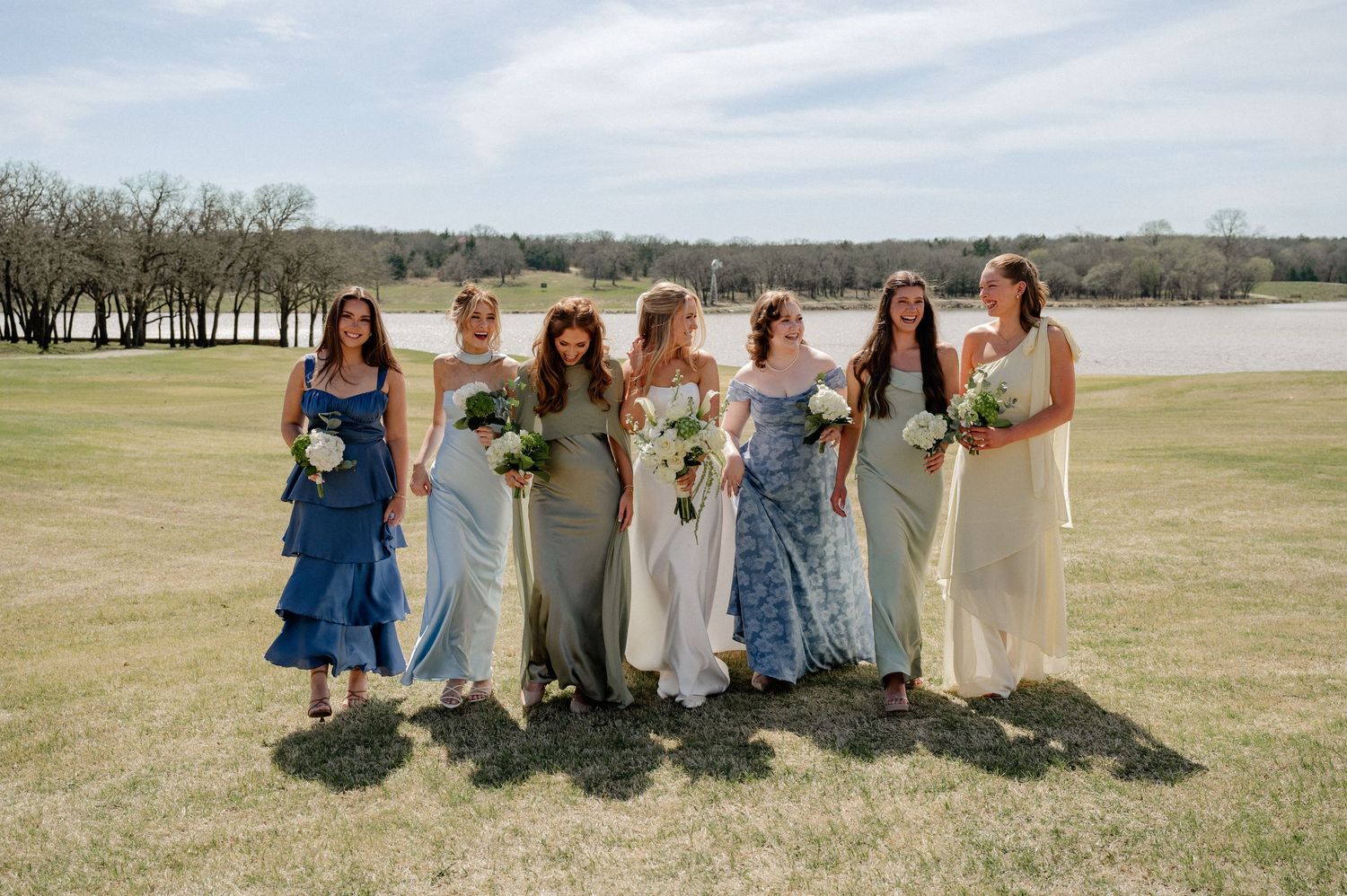 Candid photo of bride and her wedding party laughing during pre-ceremony portraits at wedding in Dallas, Texas