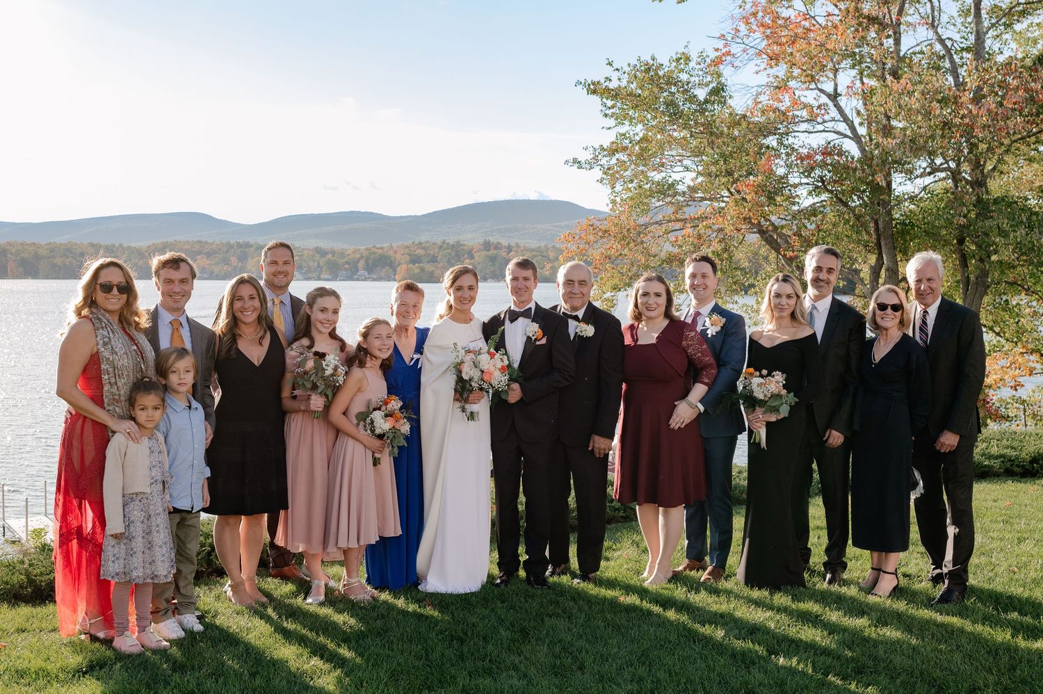 Large family photo in front of a large lake and mountains at a fall wedding in The Berkshires, Massachusetts