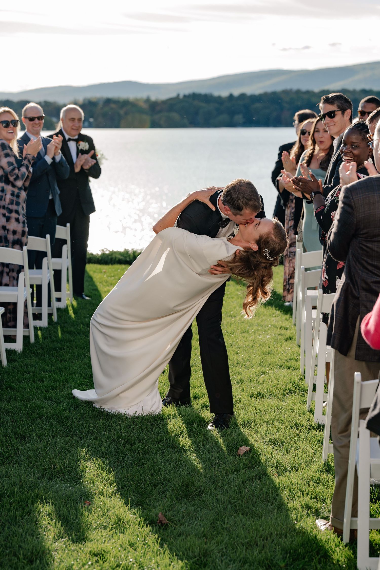 Bride and Groom kissing as they walk back down the aisle overlooking the mountains and lake in The Berkshire's Massachusetts.