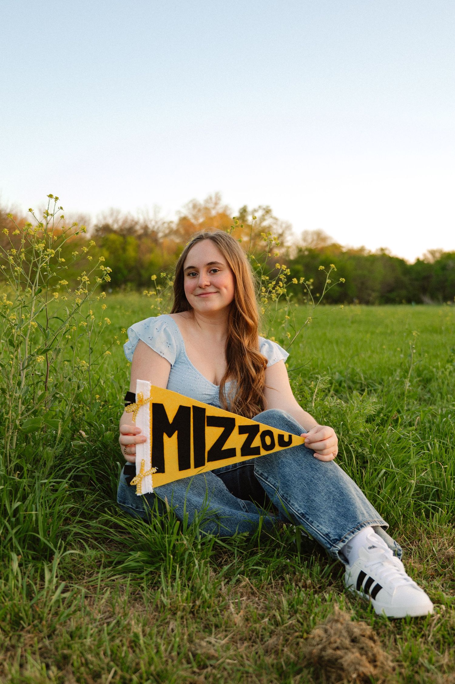 High School senior posing in wildflower fields for Spring senior photos in Dallas, Texas