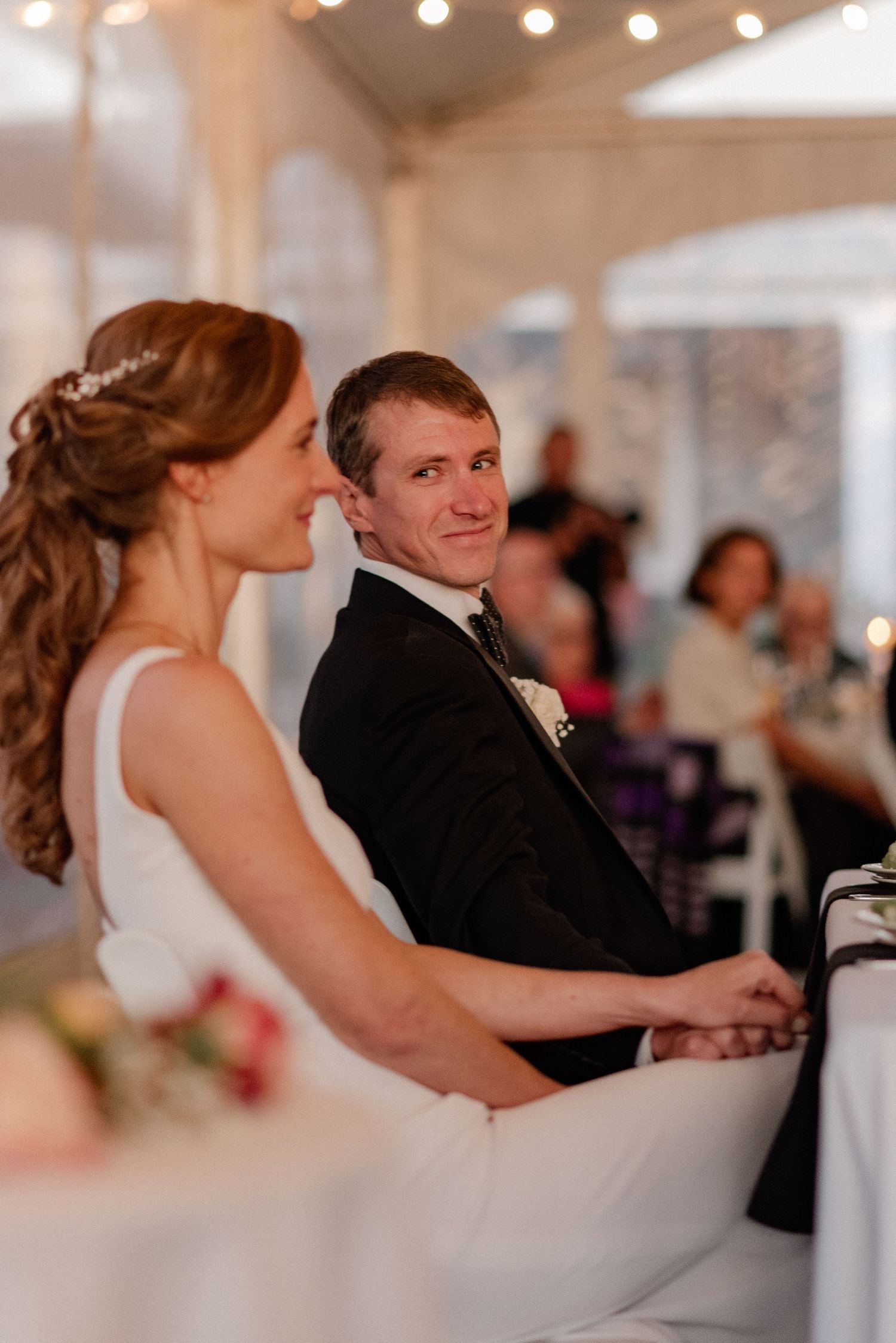 Documentary style candid of groom looking over at the bride during toasts at the wedding reception in the Berkshires Massachusetts