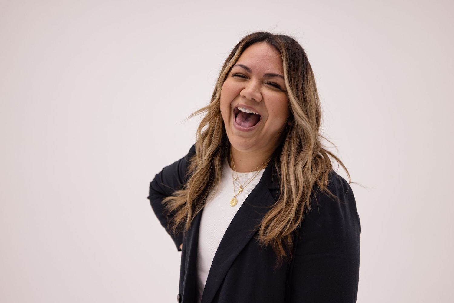 A playful headshot portrait of a female musician in front of a white studio wall