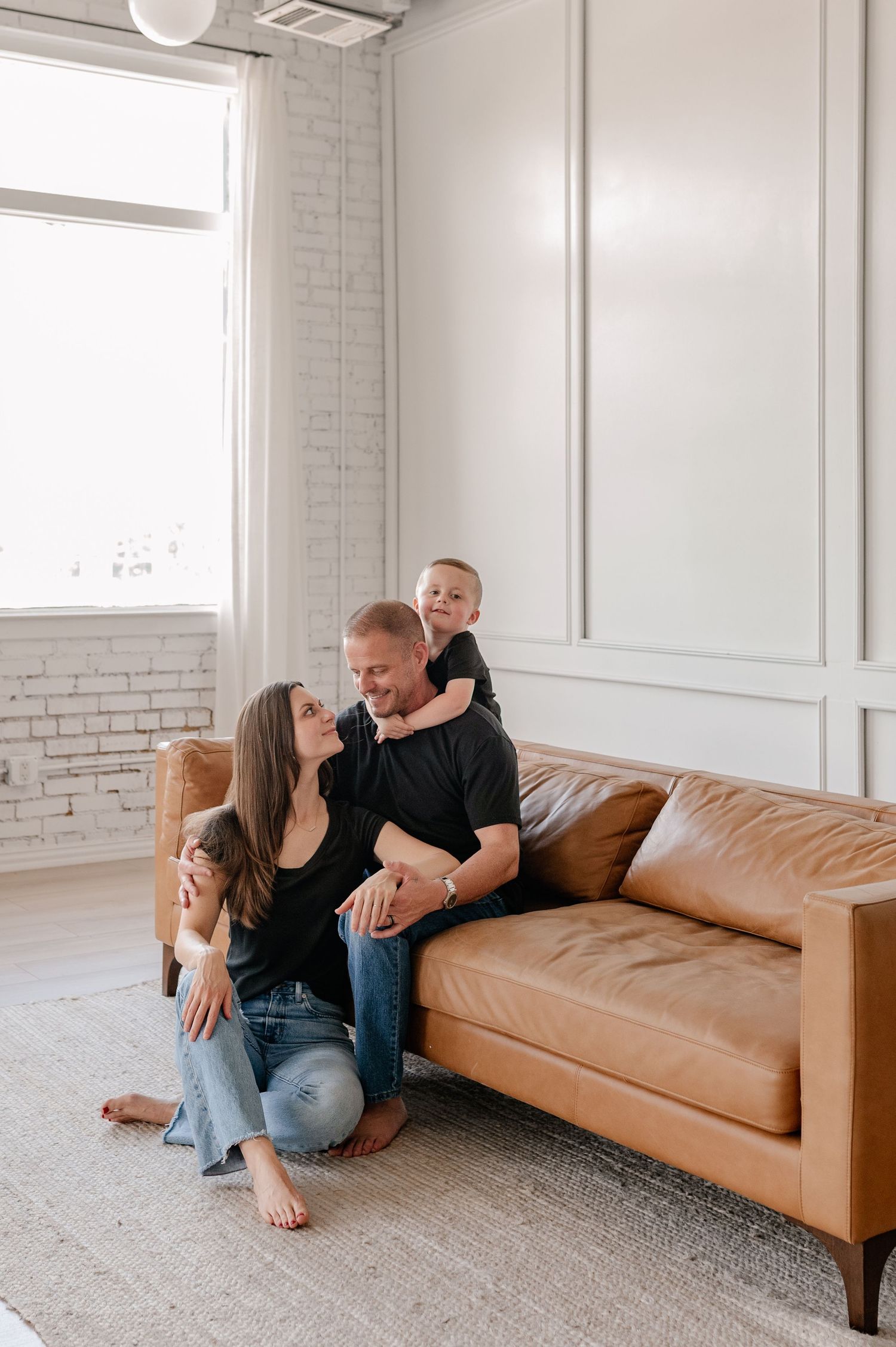 Candid lifestyle photo of family showing affectionate embraces in a bright indoor studio in Dallas, Texas